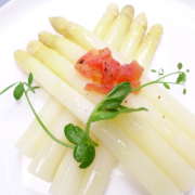 Ein Teller mit zart gegartem weißem Spargel, garniert mit Tomatenwürfeln und frischen Erbsensprossen, ergibt eine leichte Gourmet-Vorspeise. - Ihr Landhaus Scherrer aus Hamburg