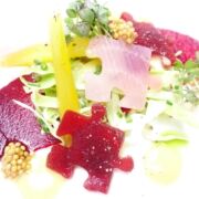 Veganes Carpaccio von junger Roter Bete - als verschiedenfarbige Puzzleteile mariniert - mit veganem Skyr und Senf-Aromen. Das Gericht ist farbenfroh und wird als vegane Vorspeise und Start ins Menü serviert.